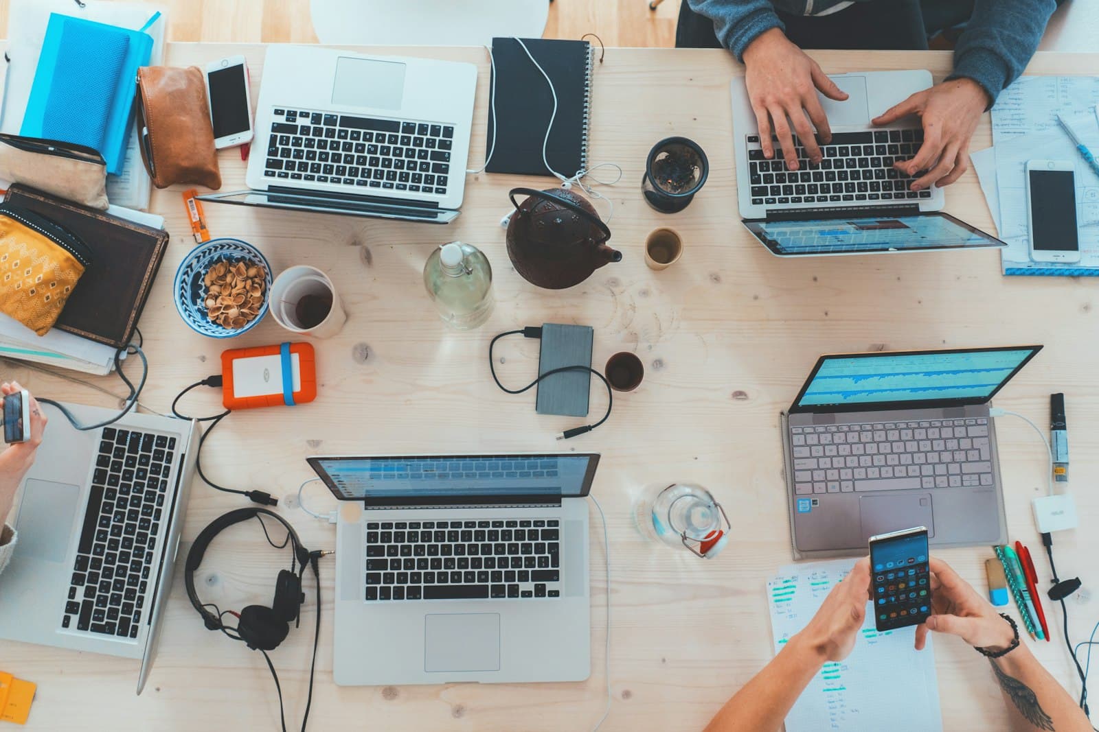 People collaborating around laptops — photo by Unsplash